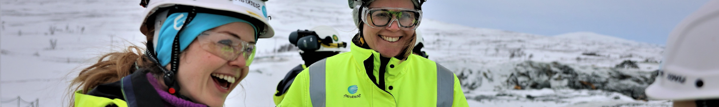 Two woman wearing safety gear and laughing at something